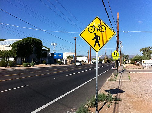 Signs along the roadway alert motorists to expect both bicycles and pedestrians in the crossing.